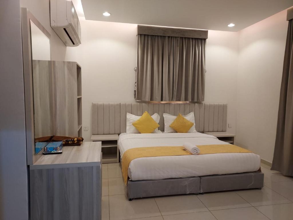 Pokój hotelowy z 2 łóżkami i biurkiem w obiekcie قرنيت الطائف للشقق المخدومة w mieście Taif