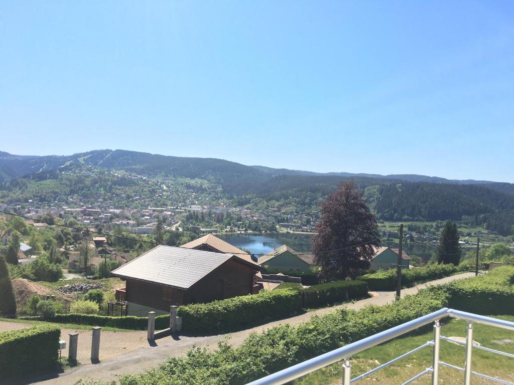 uma vista para um vale com uma casa em les charmes du lac Sauna et Spa em Gérardmer