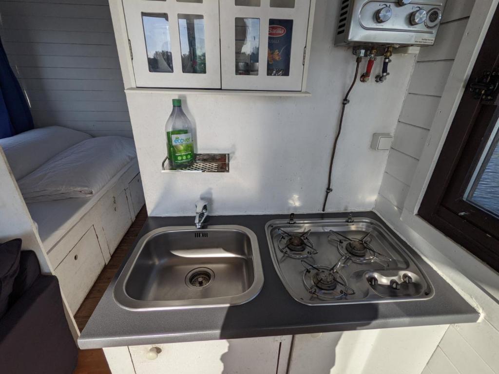 uma cozinha com um lavatório numa pequena casa em Gemütliches Hausboot mit Kamin in Berlin em Berlim