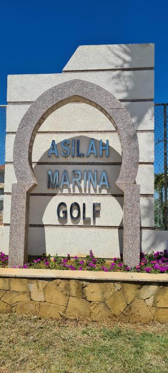 a sign for a salil marina club with flowers at ASILAH MARINA GOLF in Asilah