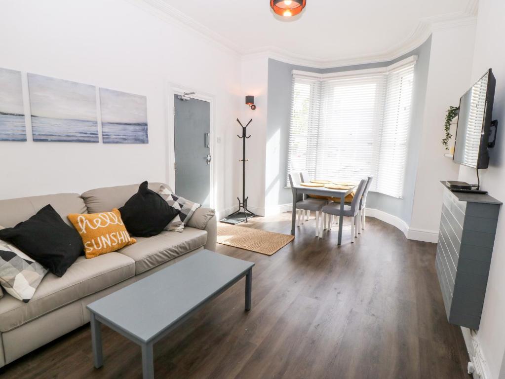 a living room with a couch and a table at Rothlea Flat 1 in Pwllheli