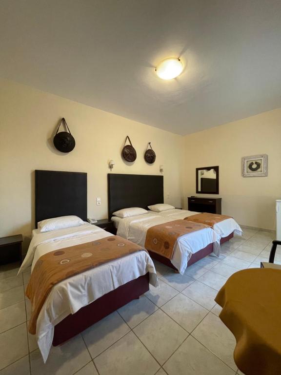 a hotel room with two beds and a mirror at Hotel Afrika in Eleonas