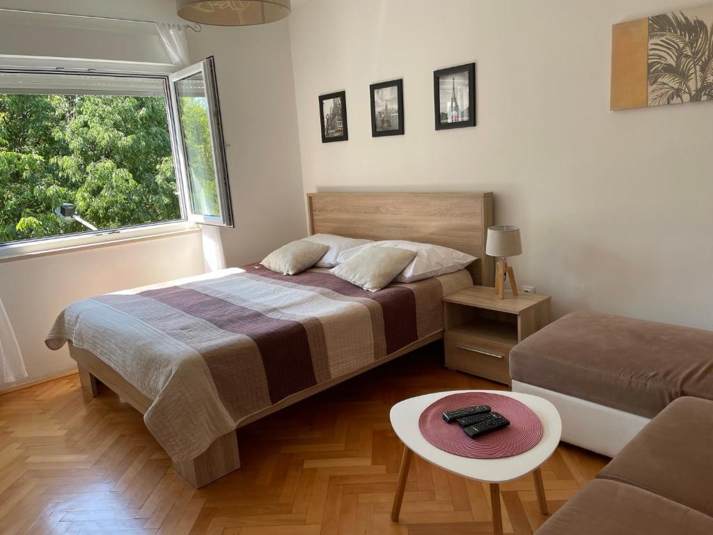 a bedroom with a bed and a couch and a window at Apartment Beauty in Pula