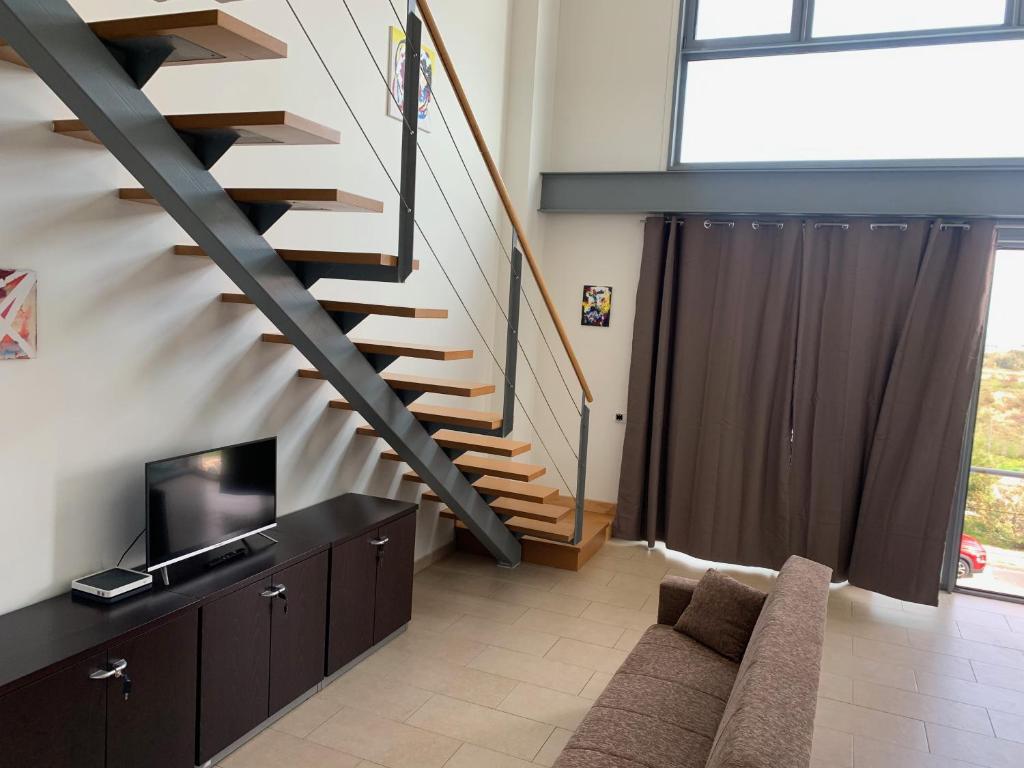 a living room with a staircase and a couch at Loft luminoso Alcorcón M-40 Madrid in Alcorcón