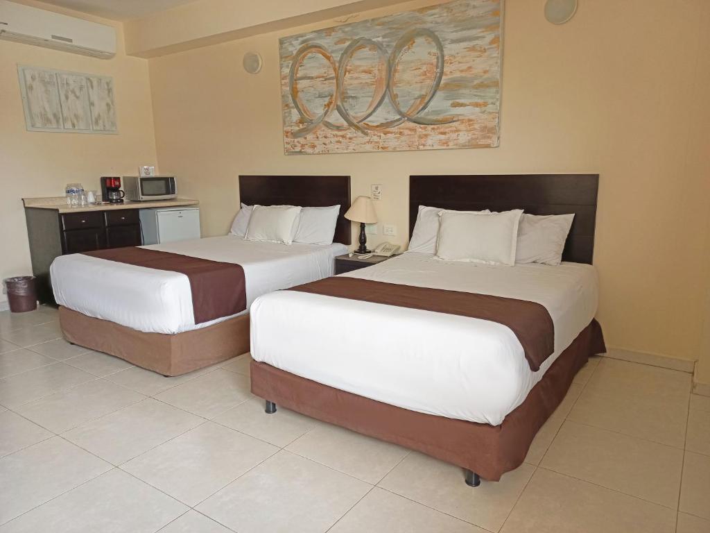 2 Betten in einem Hotelzimmer mit 2 Betten in der Unterkunft HOTEL VILLA MARGARITAS in Villahermosa