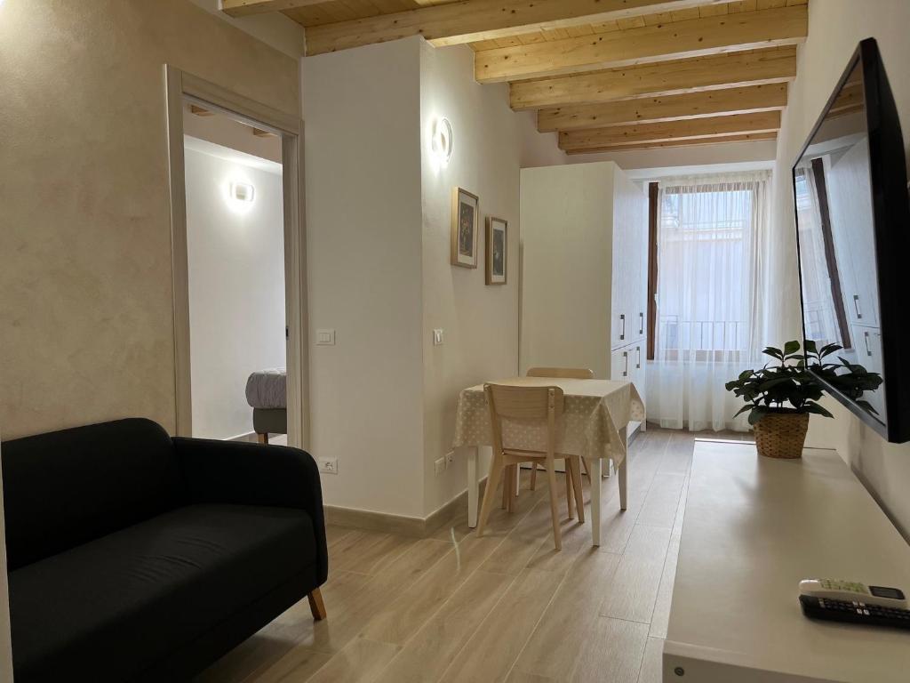 salon z czarną kanapą i stołem w obiekcie Anfite Apartments Santa Maria w mieście Desenzano del Garda