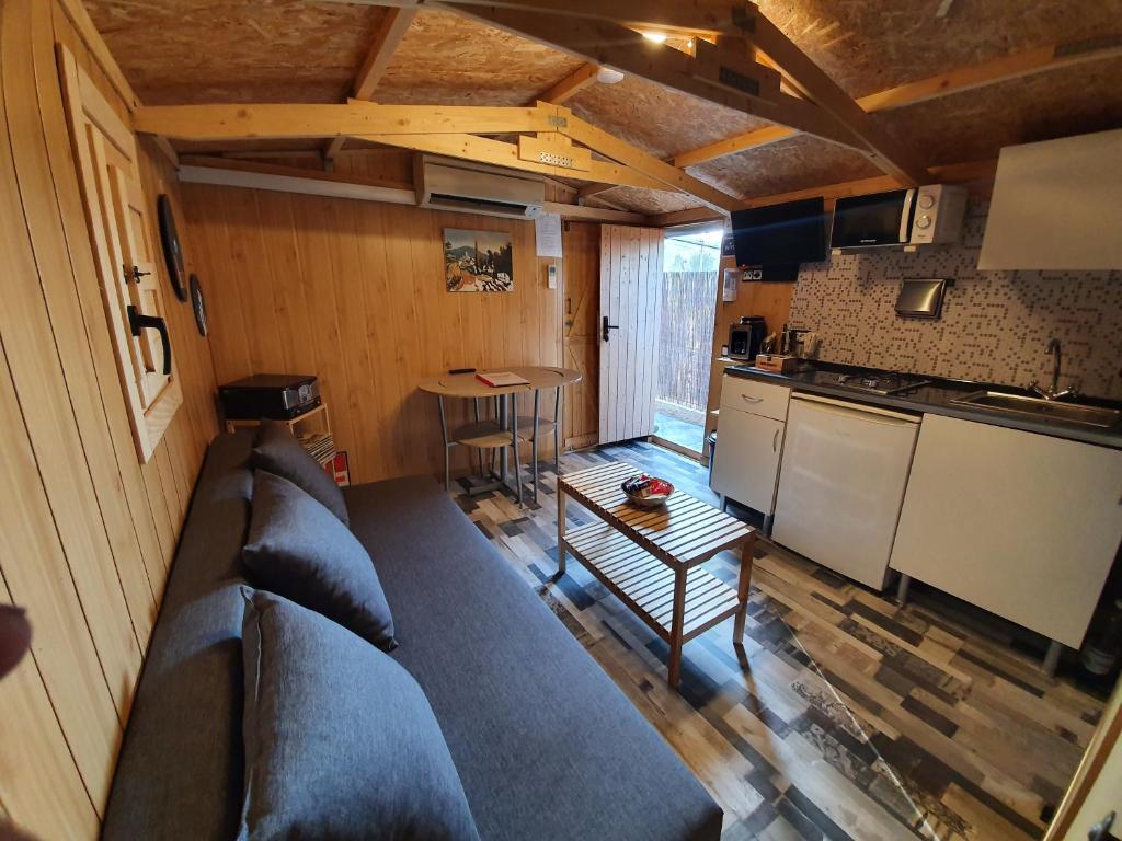 sala de estar con sofá y cocina en Little house en Vacarisas