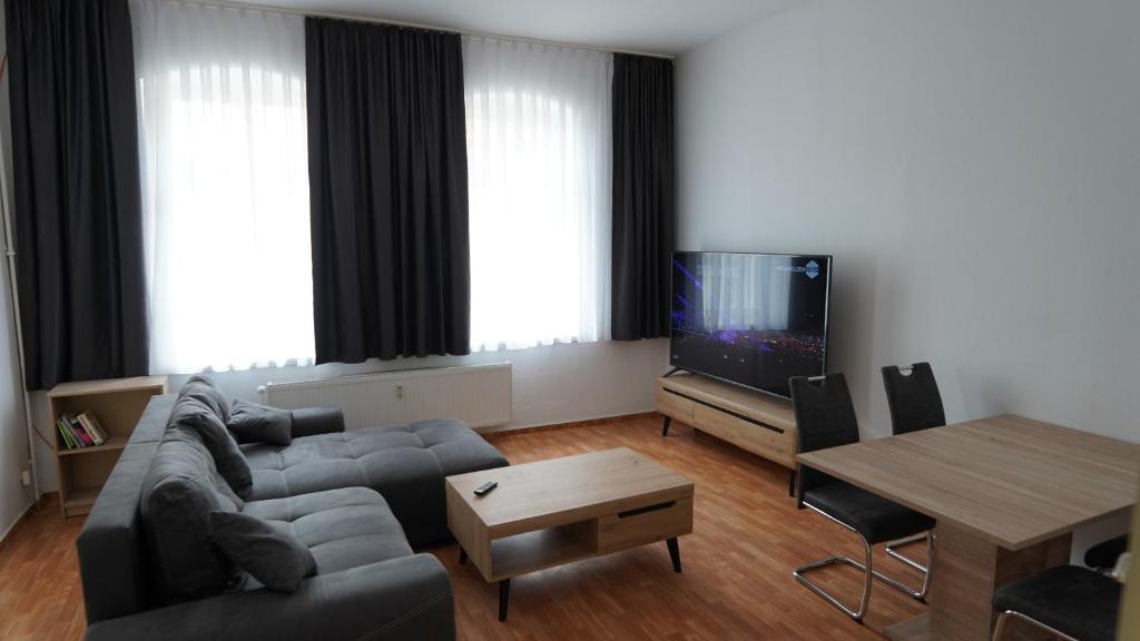 sala de estar con sofá, TV y mesa en Uta von Ballenstedt, en Ballenstedt