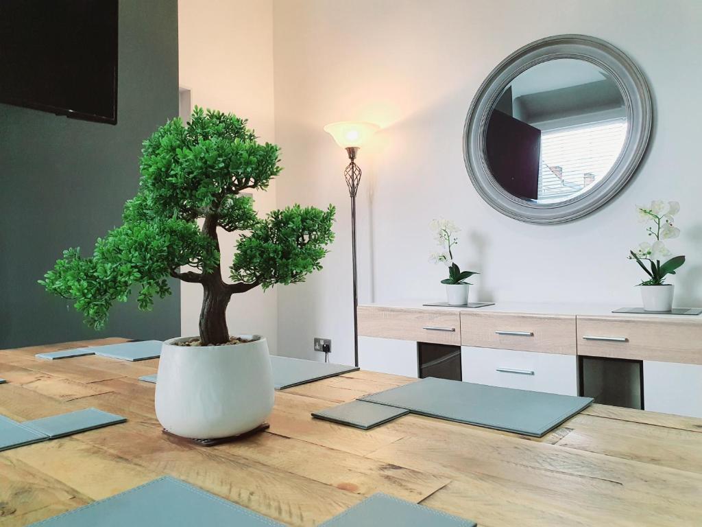 a tree sitting on top of a wooden table with a mirror at DYSA Bloomfield House in Blackpool