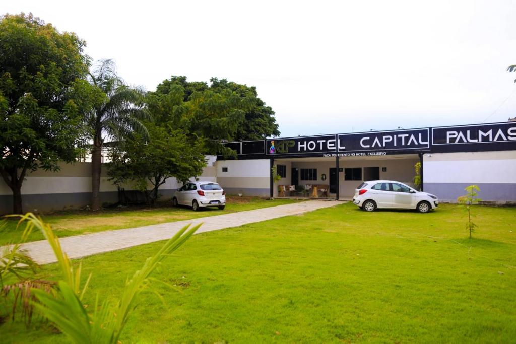 a hotel with two cars parked in front of it at HOTEL CAPITAL PALMAS in Palmas