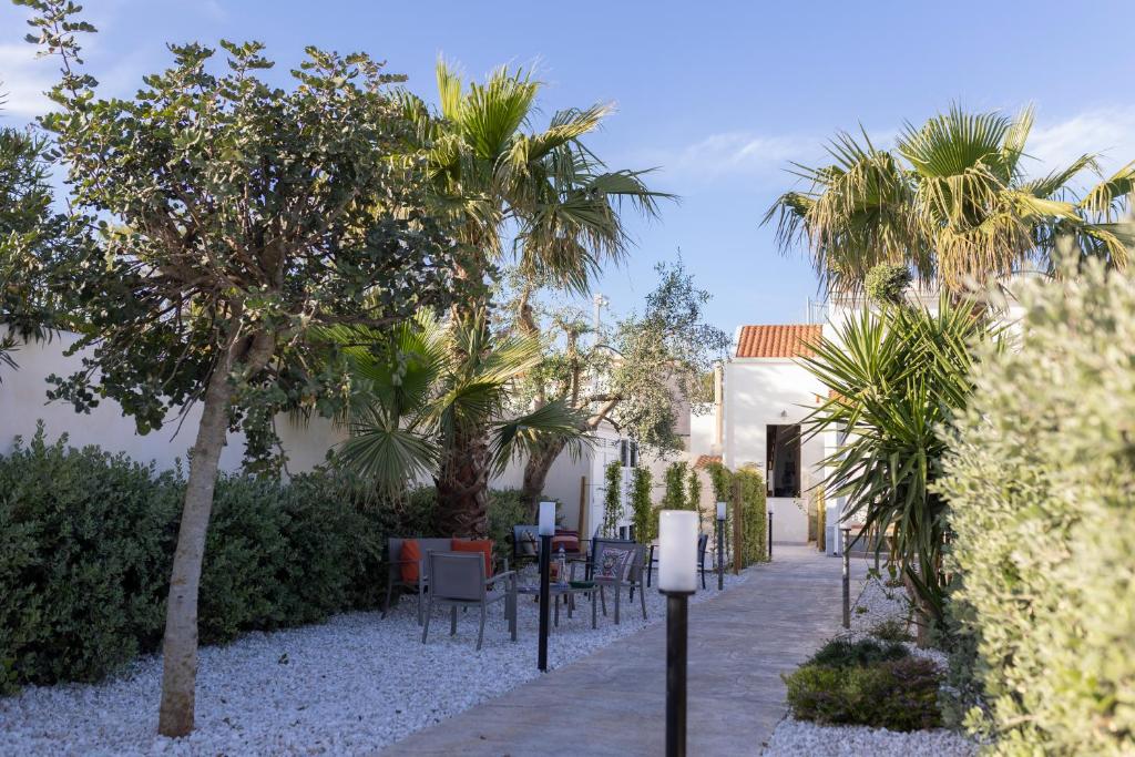 a garden with chairs and trees and a building at MrBrown - Cinzia Resort Beach in Mazara del Vallo