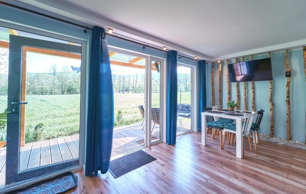 a room with sliding glass doors and a table with a desk at Marel-Apartments Domek Duna Lux Polanica Zdrój in Polanica-Zdrój