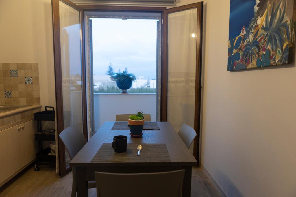a dining room table with a potted plant on it at MrBrown - Cinzia Resort Beach in Mazara del Vallo