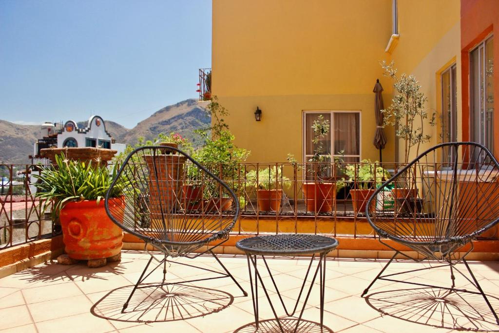 瓜納華托的住宿－Colorful family condo with terrace and free parking，阳台配有2把椅子和1张桌子