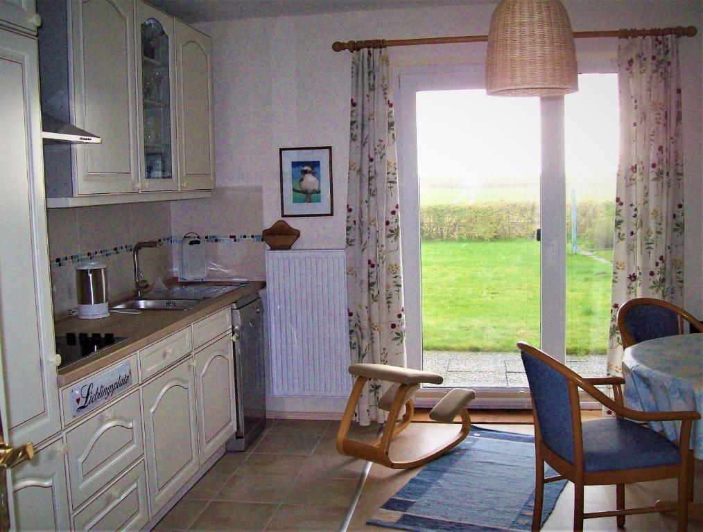 a kitchen with a sink and a table and a window at Haus-Halligblick-Ferienwohnung-Pellworm in Dagebüll