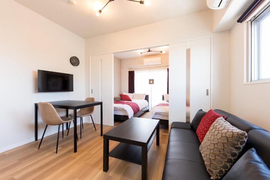ein Wohnzimmer mit einem Sofa und einem Tisch in der Unterkunft SG RESIDENCE INN HAKATA - Vacation STAY 61970v in Fukuoka