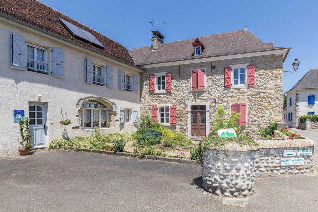 a large stone house with red shuttered windows at La Grange de Georges in Lay-Lamidou