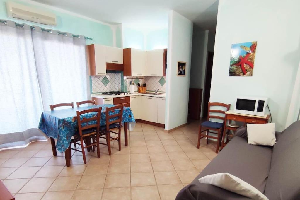 cocina y sala de estar con mesa y sillas en Casa Paguro, la Tua casa in Sardegna en Porto San Paolo