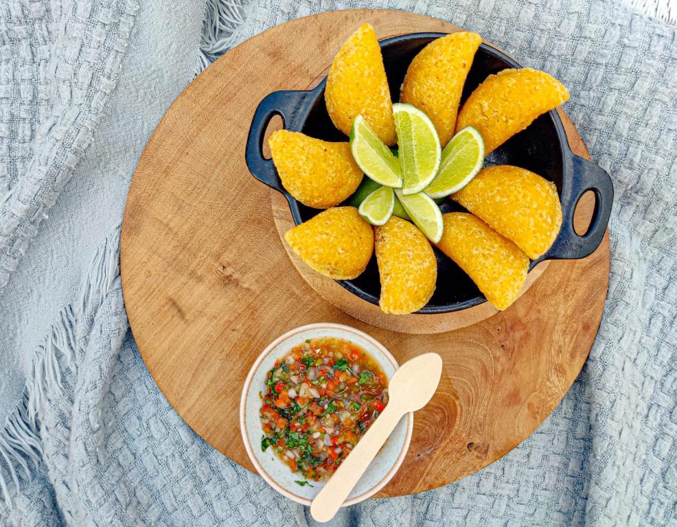 una ciotola di frutta e una ciotola di salsa su un tagliere di AKOA GLAMPING Eco-Luxury Hotel a Guarne