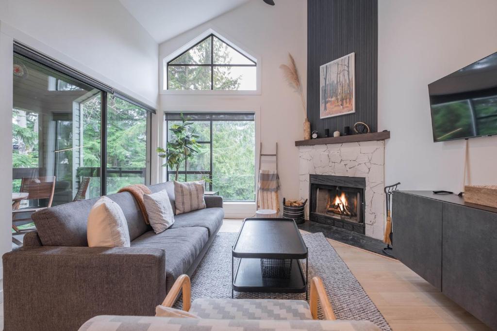a living room with a couch and a fireplace at Powderview 24 by Outpost Whistler in Whistler