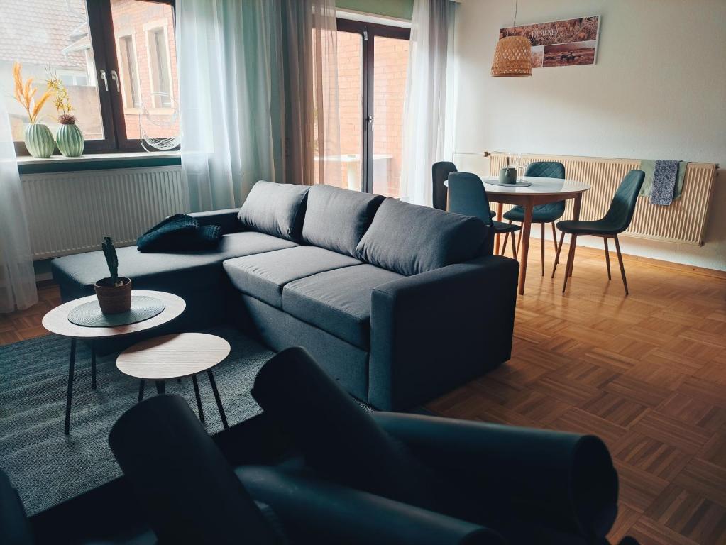 salon z kanapą, stołami i krzesłami w obiekcie Maison Mellie w mieście Oberhausen