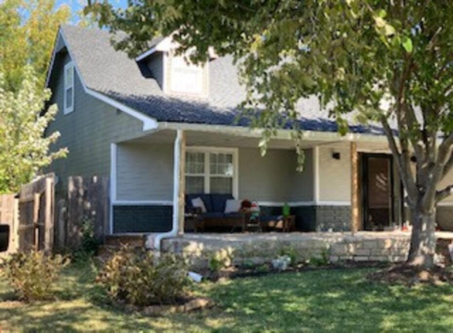 una casa bianca con un portico e un albero di WOW! Spacious Retreat & amazing yard 2400+4bd/3bth a Wichita
