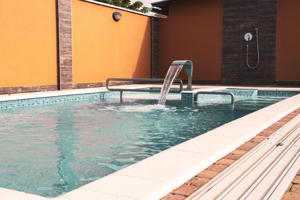 a swimming pool with a water fountain at Fazekasház in Nagykáta