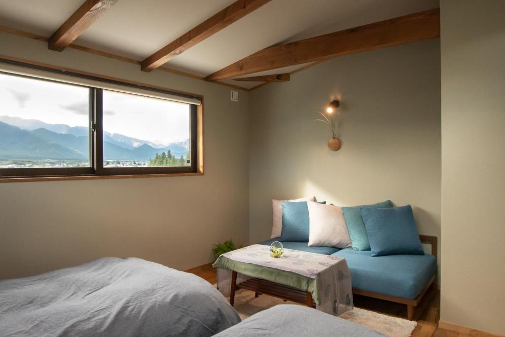 a bedroom with a bed and a blue couch and a window at CANOA GUEST HOUSE A room - Vacation STAY 50937v in Ikeda