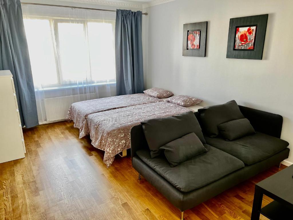 a bedroom with a bed and a couch at Vilniaus 96 apartments in Ukmergė