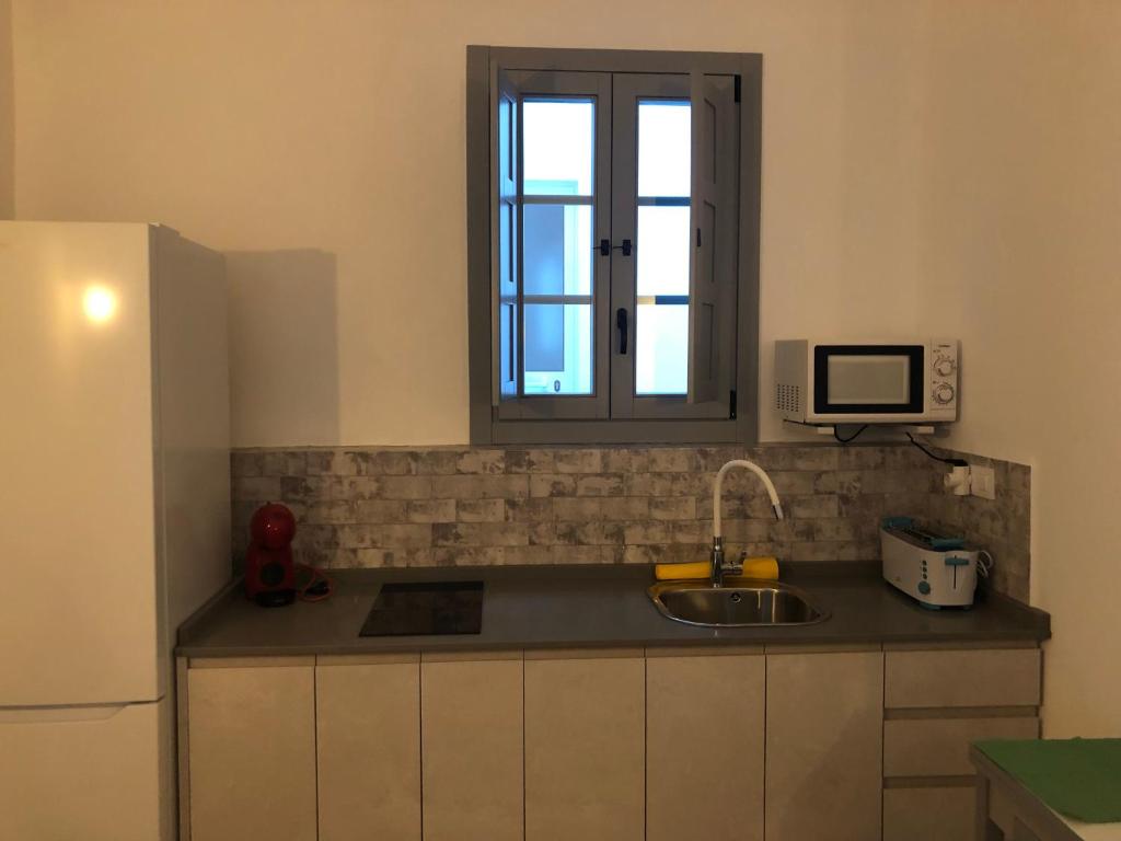 a small kitchen with a sink and a window at Apartamentos Casa la Costanilla in Vejer de la Frontera