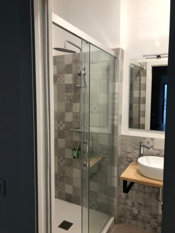 a bathroom with a glass shower with a sink at Apartamentos Casa la Costanilla in Vejer de la Frontera