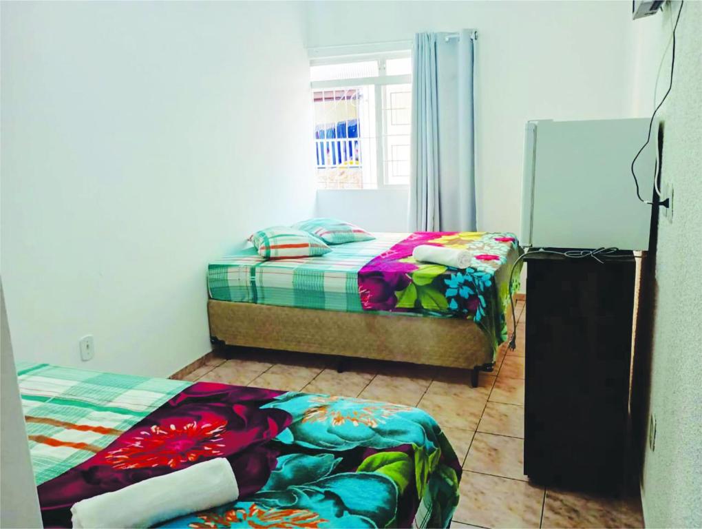 a bedroom with two beds and a window at Pousada Jesus Misericordioso in Aparecida