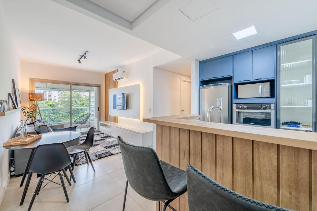 a kitchen with blue cabinets and a table and chairs at Trend Nova Carlos Gomes - 406 in Porto Alegre