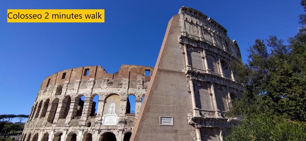 un antiguo edificio con una torre delante de él en Teatime al Colosseo, en Roma