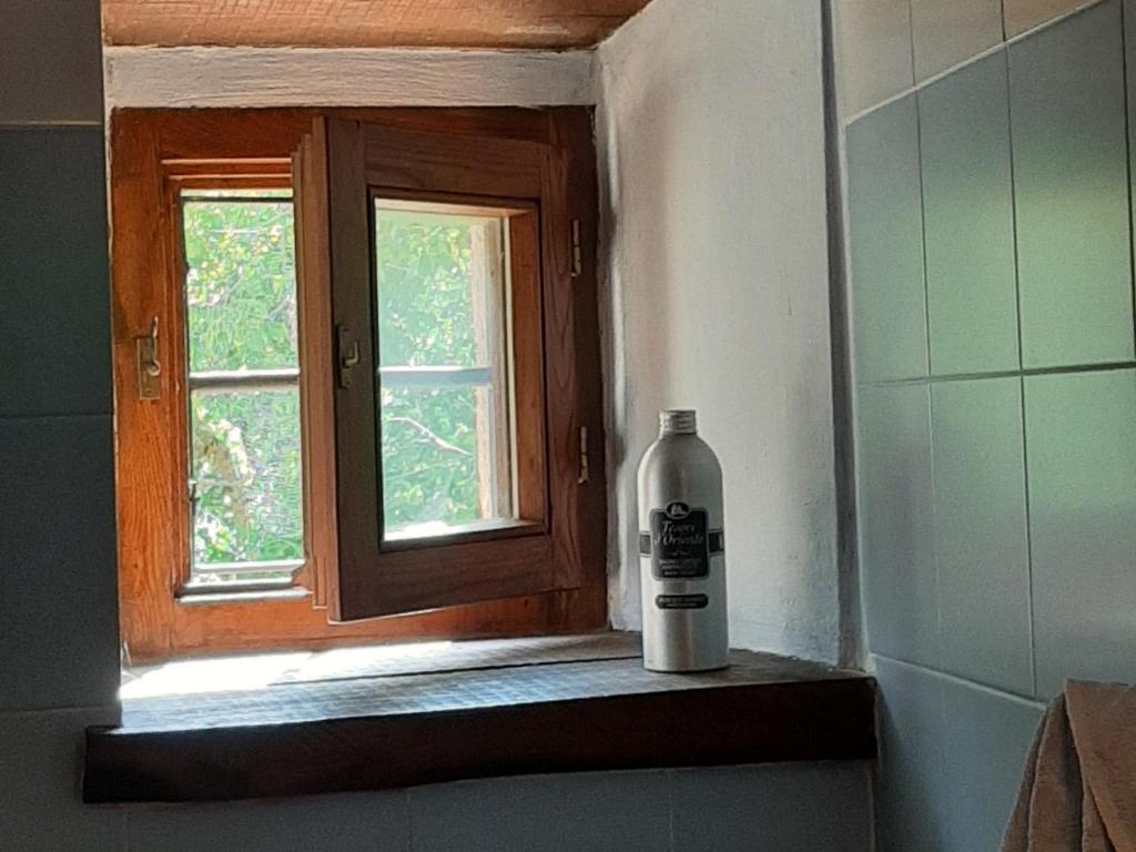 butelka leżąca na półce obok okna w obiekcie Casa Piccolo Borgo w mieście Campello sul Clitunno