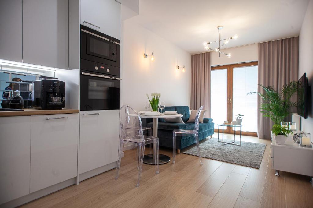 een keuken en een woonkamer met een tafel en een bank bij Apartament Greno Kielce in Kielce