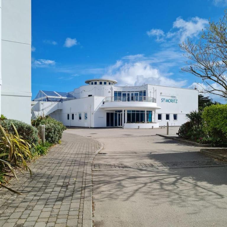 a white building with a sign on it at St Moritz Hotel and Cowshed Spa in Polzeath