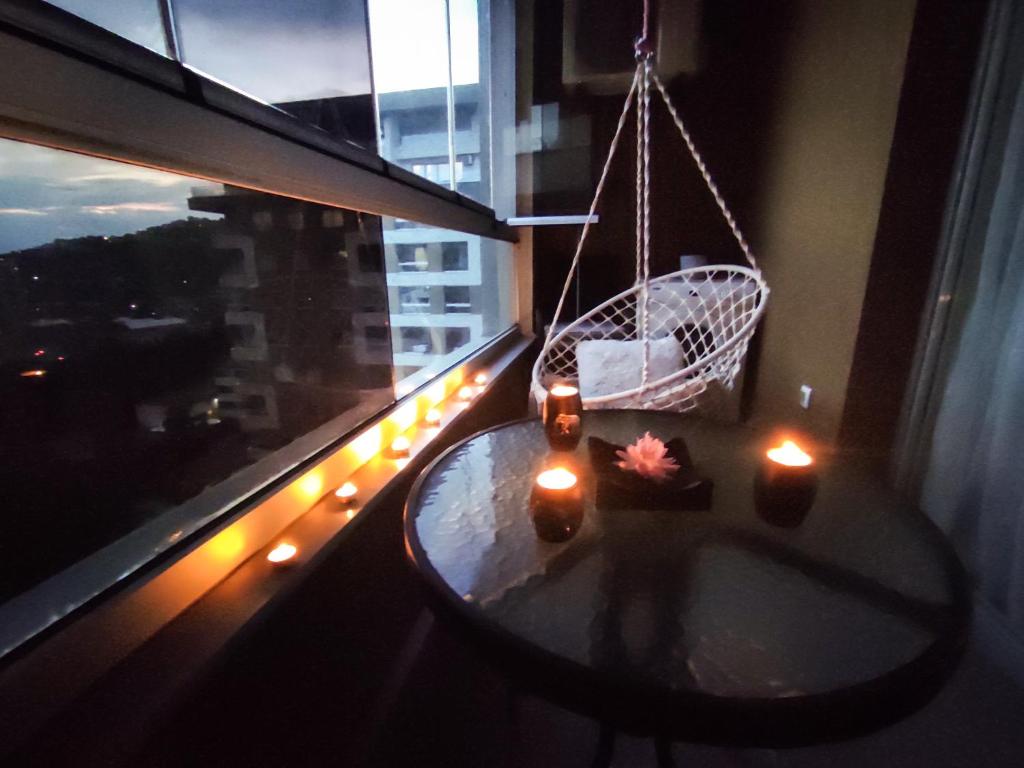 um quarto com uma mesa e uma janela com velas em Sky Way Studio Apartment em Saraievo