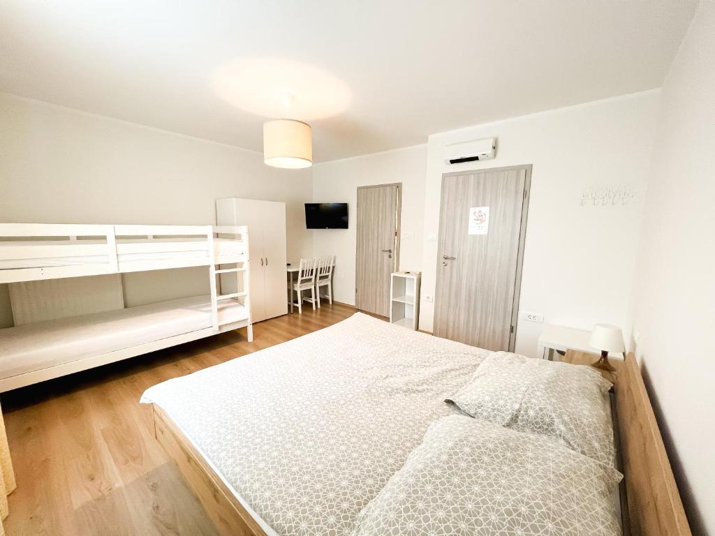 ein Schlafzimmer mit einem großen weißen Bett in einem Zimmer in der Unterkunft HOP HOUSE Garni Hotel in Postojna