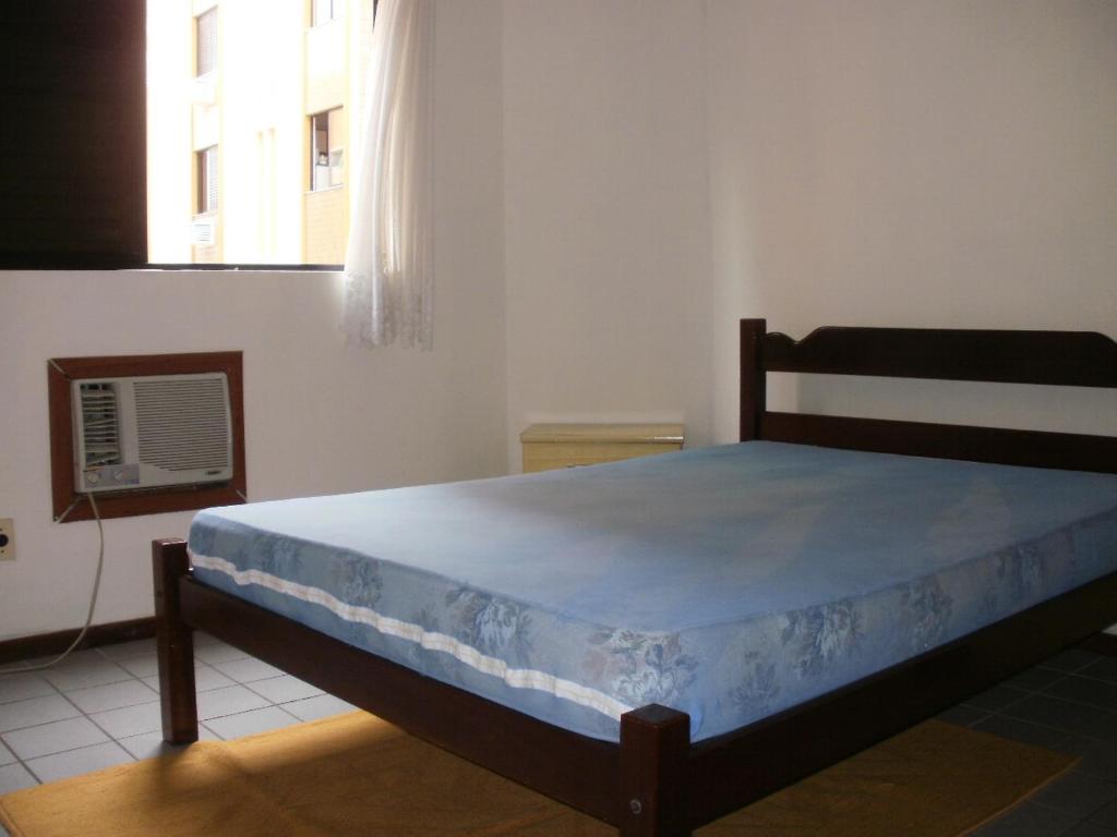 a bedroom with a bed in a room with a window at Larus 107 in Florianópolis