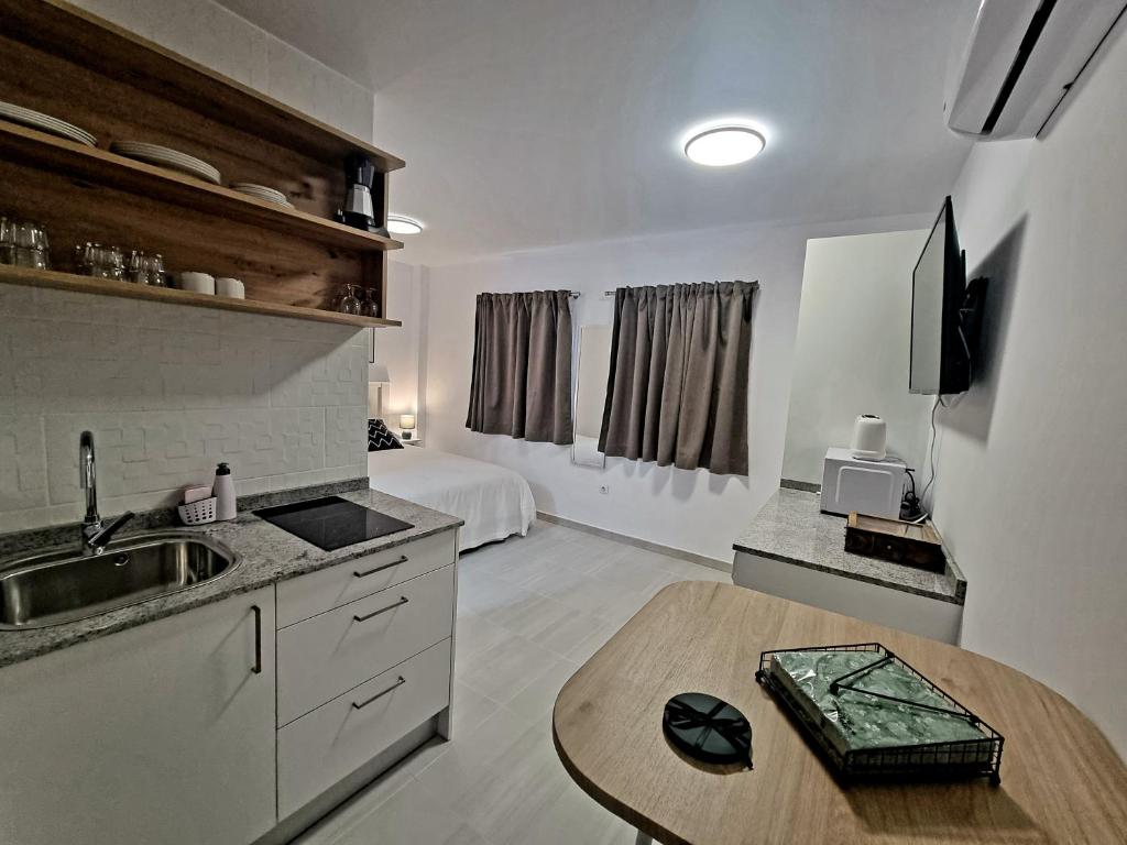 uma cozinha com um lavatório e uma mesa num quarto em Cardón Jandía 2B em Morro del Jable