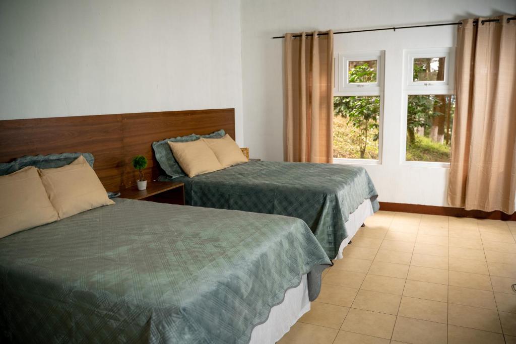 a hotel room with two beds and a window at Cabañas Don Chinto in San José Pinula