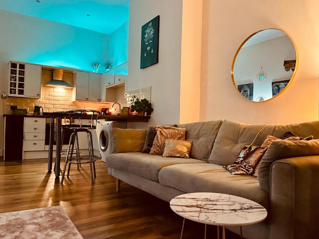 uma sala de estar com um sofá e uma cozinha em Southsea Retreat em Southsea