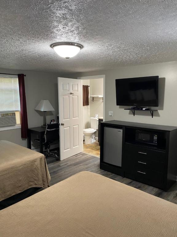 a hotel room with two beds and a flat screen tv at The New Lantern Motel in Allegany