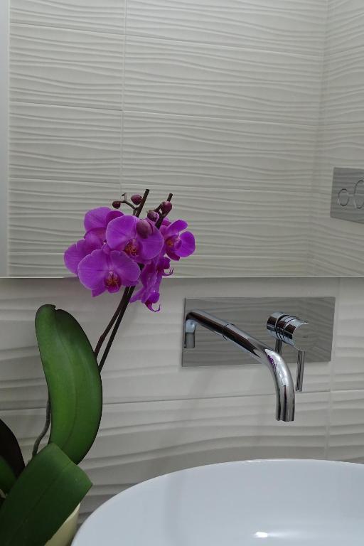 a purple flower sitting next to a bathroom sink at Sailor's House Porto Cervo in Porto Cervo