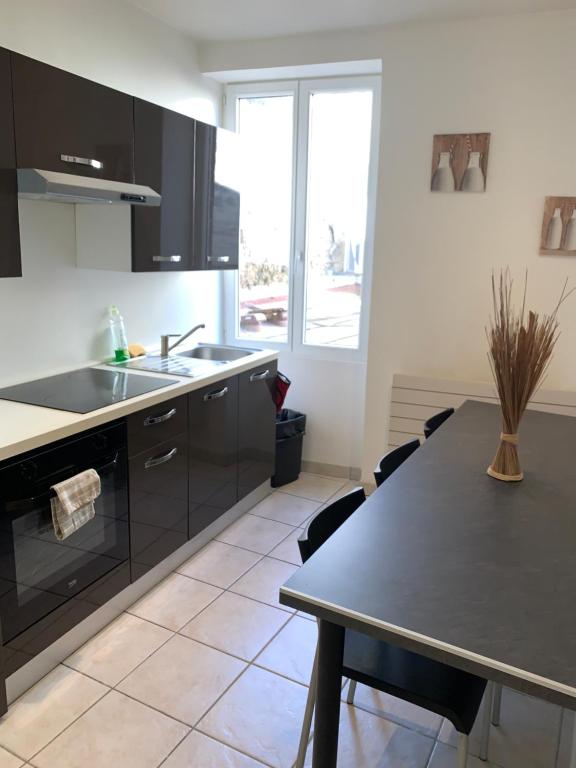 a kitchen with a table and a sink at Appartement de la nation 1 in La Tour-du-Pin
