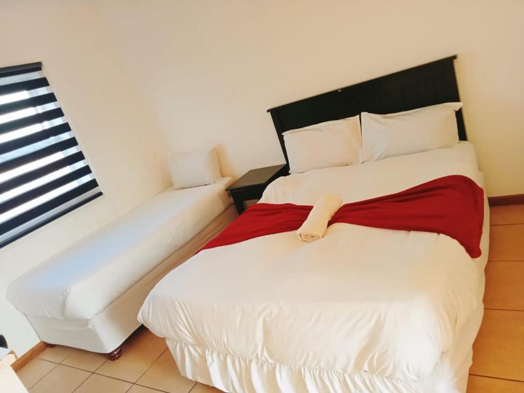 En eller flere senge i et værelse på Palm Heaven B&B