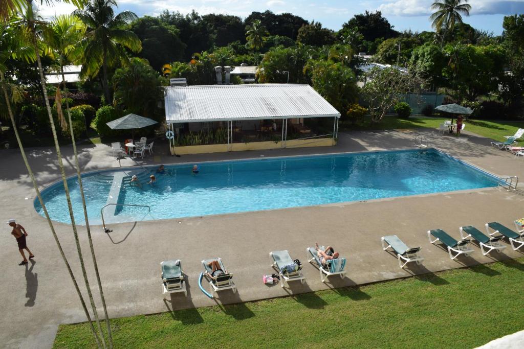 una vista dall'alto di una piscina con persone sedute su sedie di Goldenview a Saint James