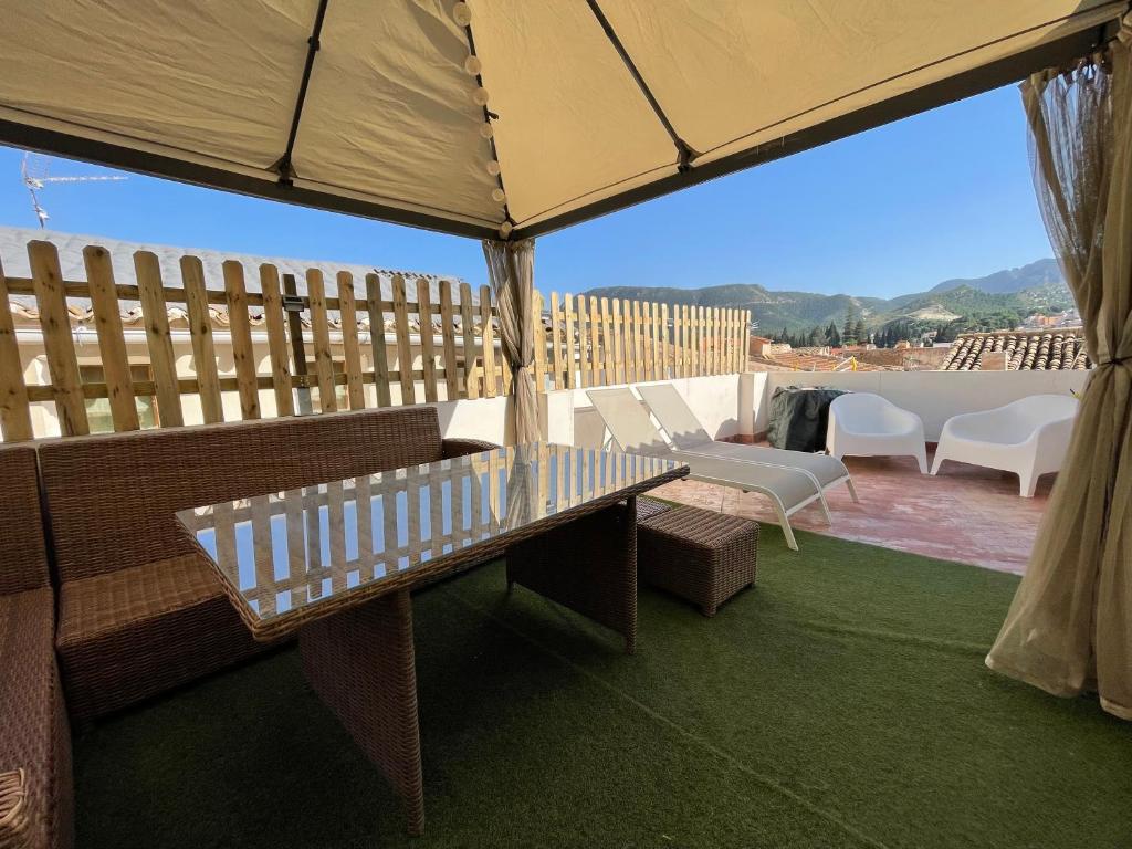 eine Terrasse mit einem Tisch, Stühlen und einem Sonnenschirm in der Unterkunft Casa Rural Villa Leire en pleno corazón del Valle Ricote in Blanca