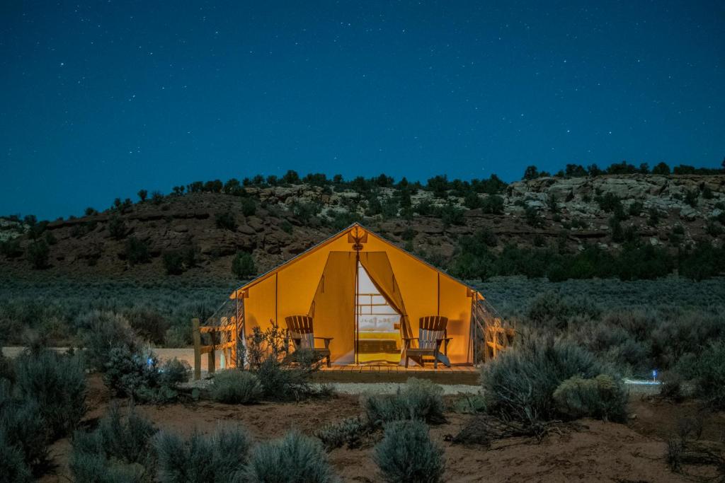 a large yellow tent in the desert at night at BaseCamp 37° in Kanab
